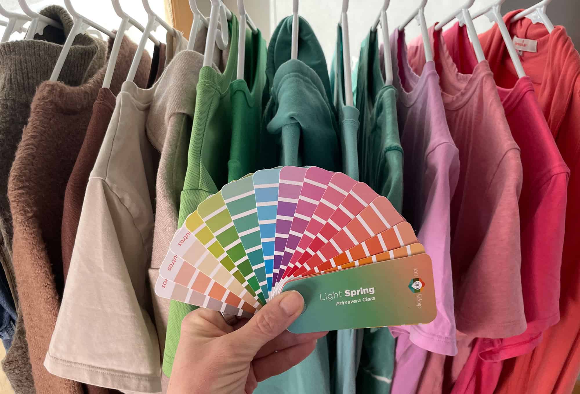 Light spring season color fan in front of a rack of matching clothes